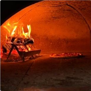 Pizza proaspăt scoasă din cuptorul cu lemne al Pizzeriei Rimini